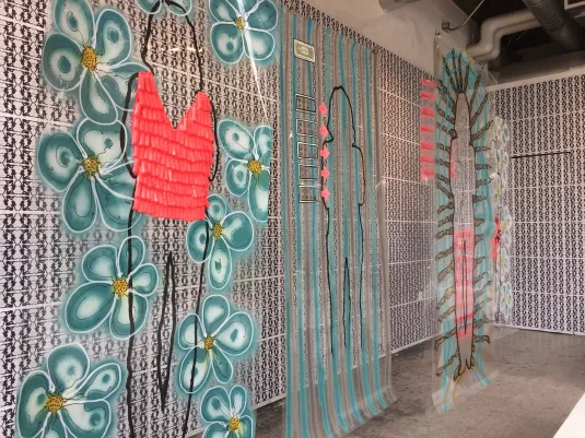 Installation view: layered painted transparencies over ERA-text wallpaper.
