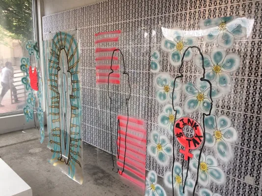 Installation view: silhouettes with stripes and flowers against ERA text.